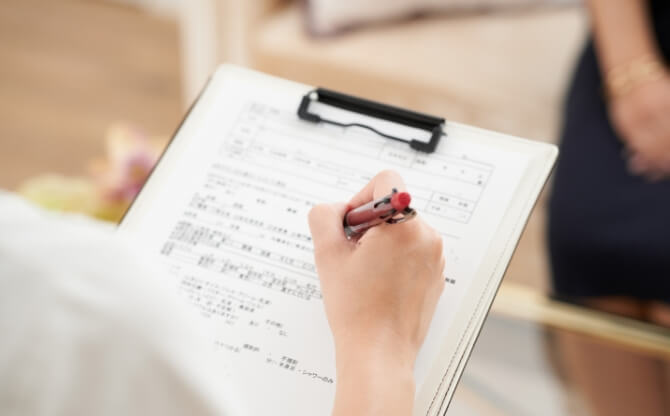 専門学校の学生アンケート用紙に記入する手元のクローズアップ