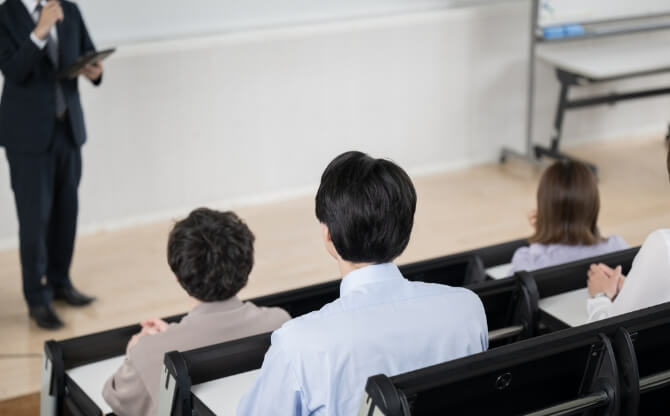 教室で講義を受ける学生たちと講師の授業風景。教務課・就職課責任者からアドバイスの様子